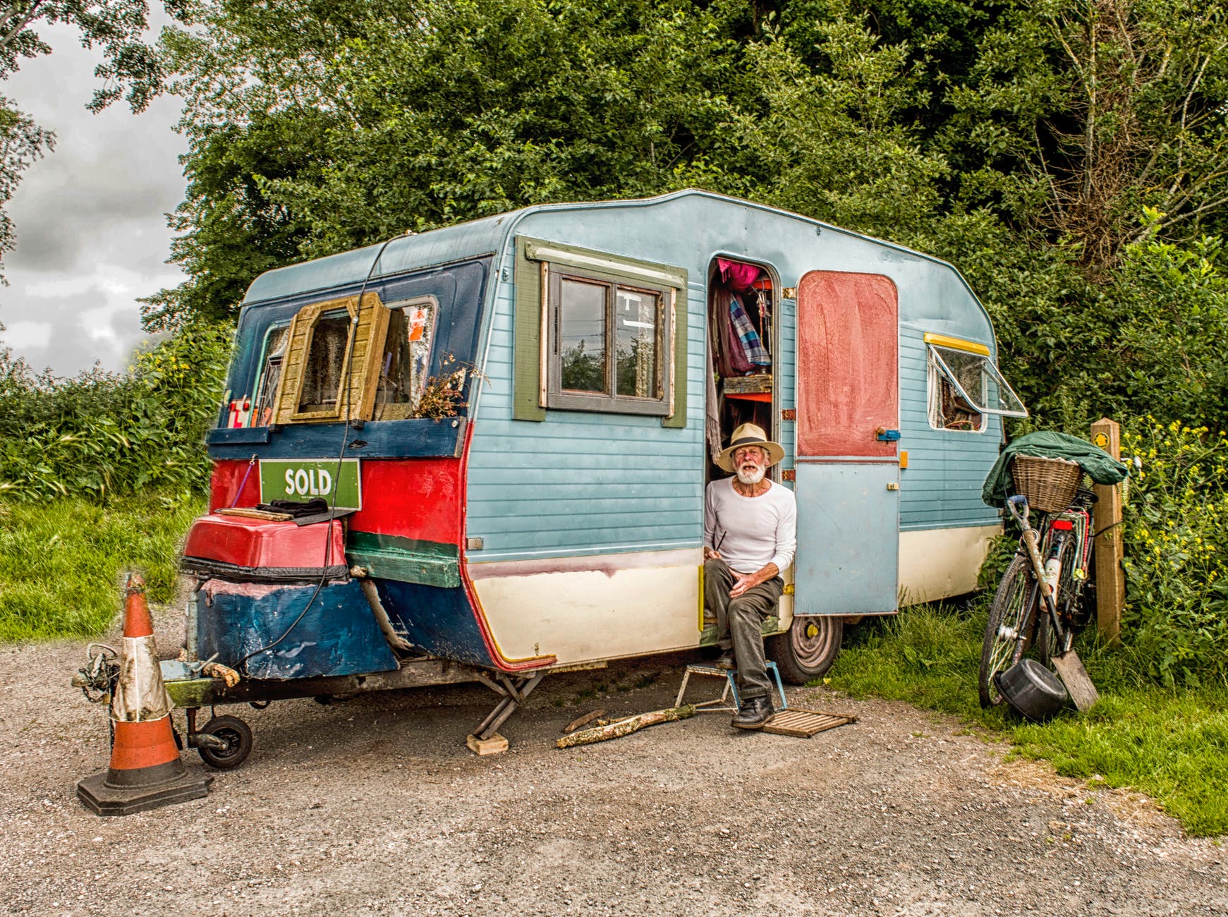 photo of a man in white long sleeved top on blue and white pop up camper