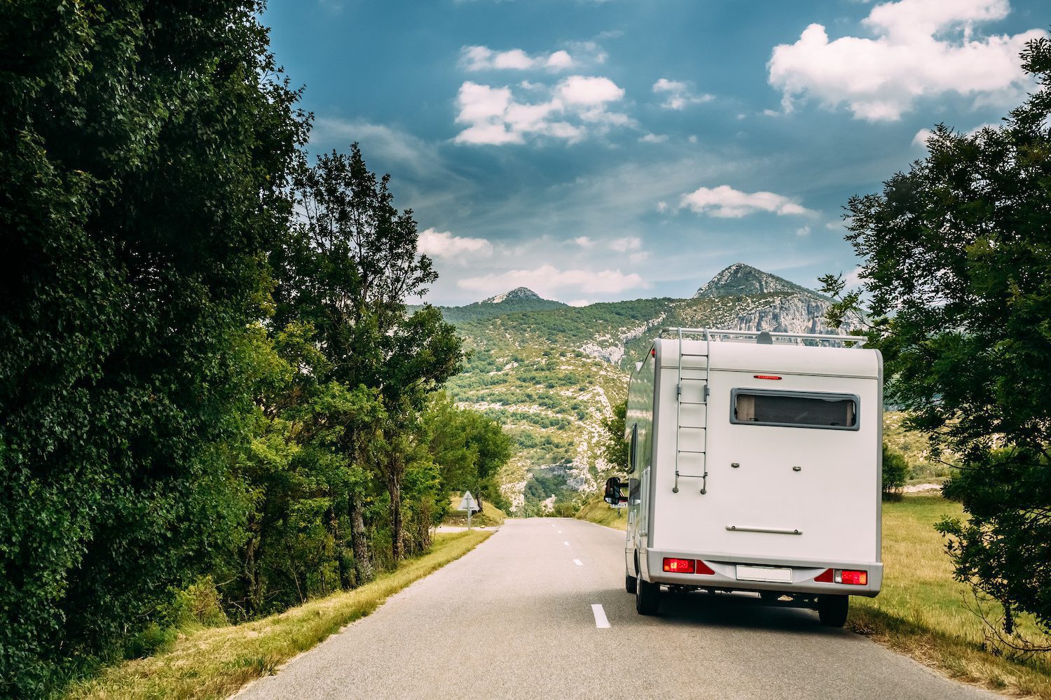 White Colour Motorhome Car Goes On Road On Background Of French Mountain Nature Landscape.