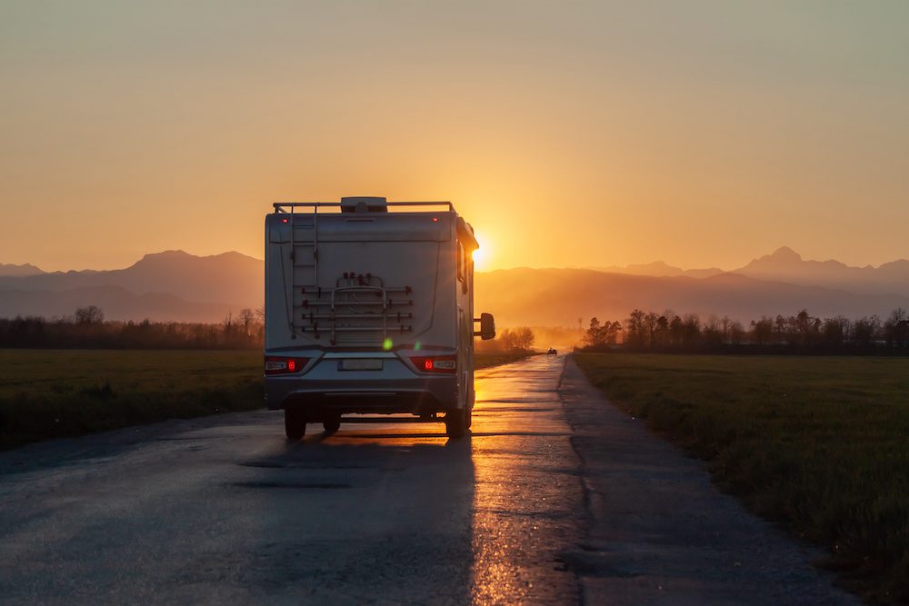 campervan on the road heading to sunset